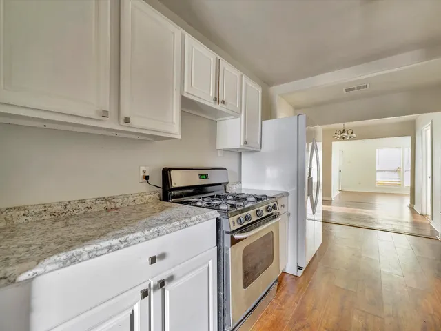 a kitchen with granite countertop a sink a stove and cabinets