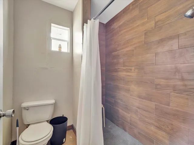 a white toilet sitting next to a shower curtain