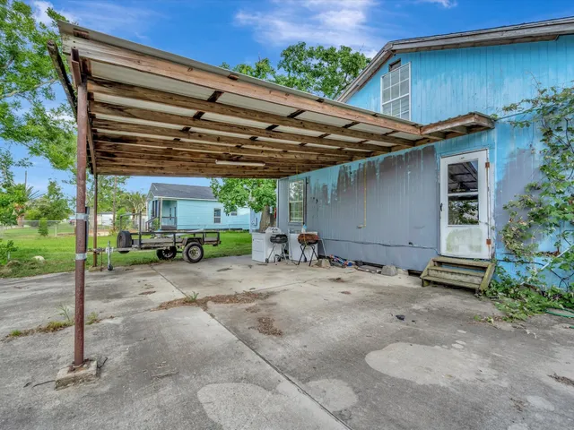 a view of a patio with table and chairs under an umbrella