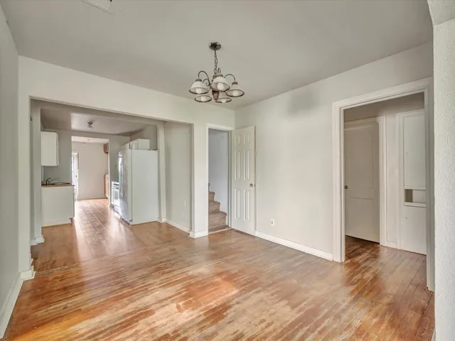 a view of a livingroom with a chandelier fan and wooden floor