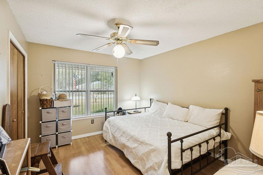 5132 Rowe Trail Pace, FL 32571 - Photo 13 of 26 a bedroom with a bed and a chandelier