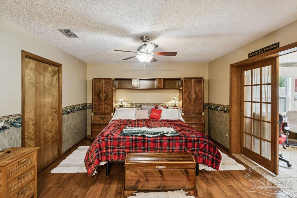 5132 Rowe Trail Pace, FL 32571 - Photo 18 of 26 a bedroom with a bed and a chandelier