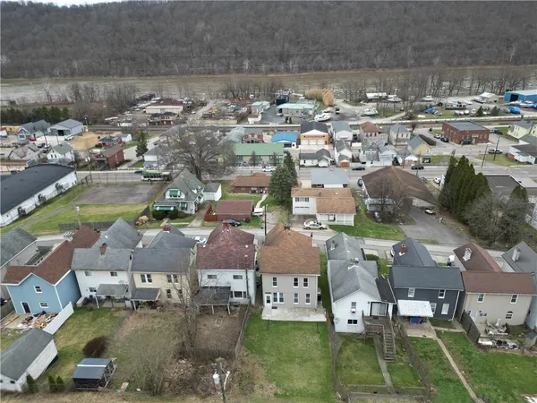 an aerial view of residential houses with outdoor space and parking
