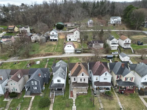 a view of a white house with a big yard and potted plants