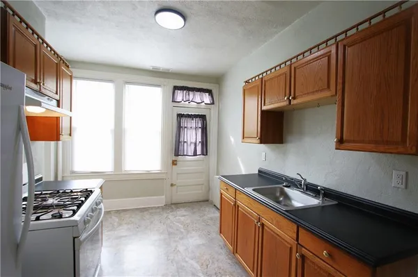 a kitchen that has a sink a stove and a window