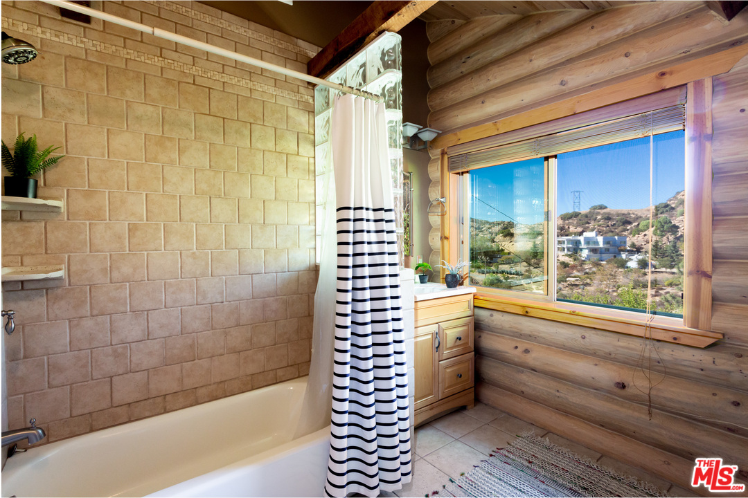 7429 Studio Road West Hills, CA 91304 - Photo 28 of 44 a bathroom with a bathtub and next to a window