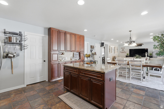 1652 West 800 South Lehi, UT 84043 - Photo 27 of 27 Kitchen with light stone counters, open floor plan, a kitchen island, and dark stone finish floors
