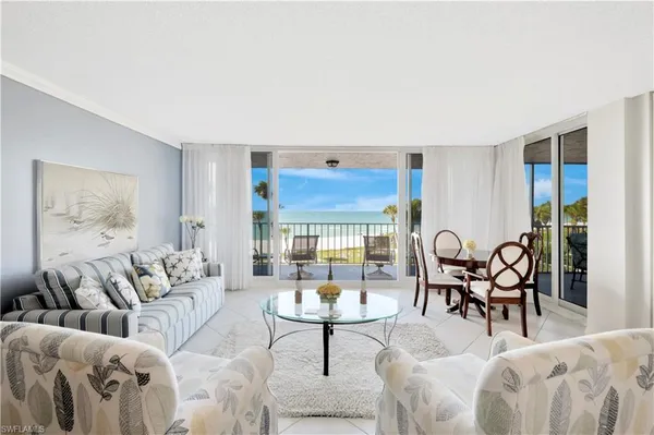 a living room with furniture a rug and a large window