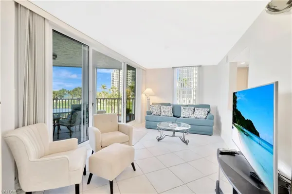 a living room with furniture tv and large window