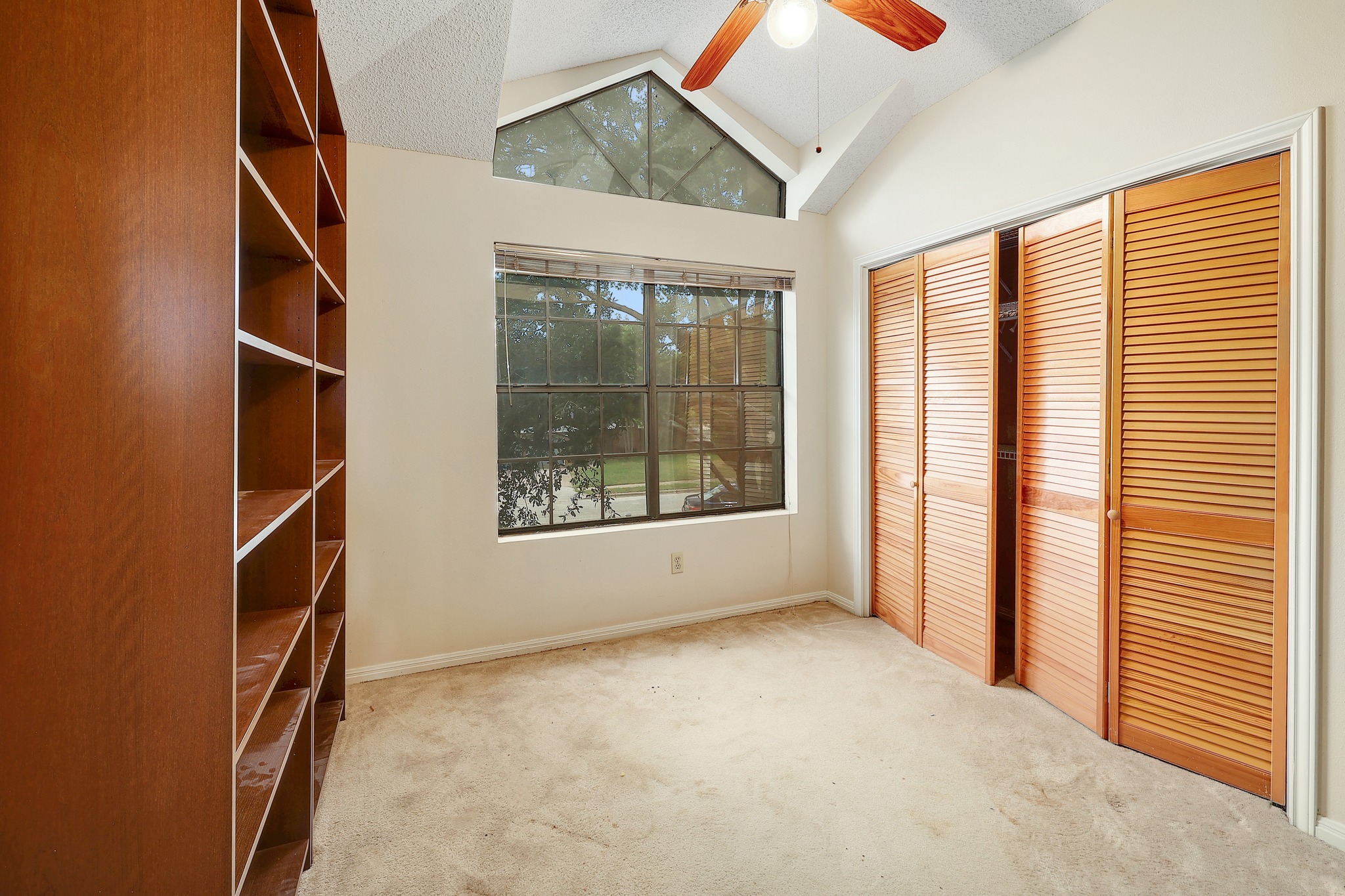 2202 Warfield Way Austin, TX 78728 - Photo 25 of 32 A versatile space features a vaulted ceiling, built-in shelving, and a prominent window.