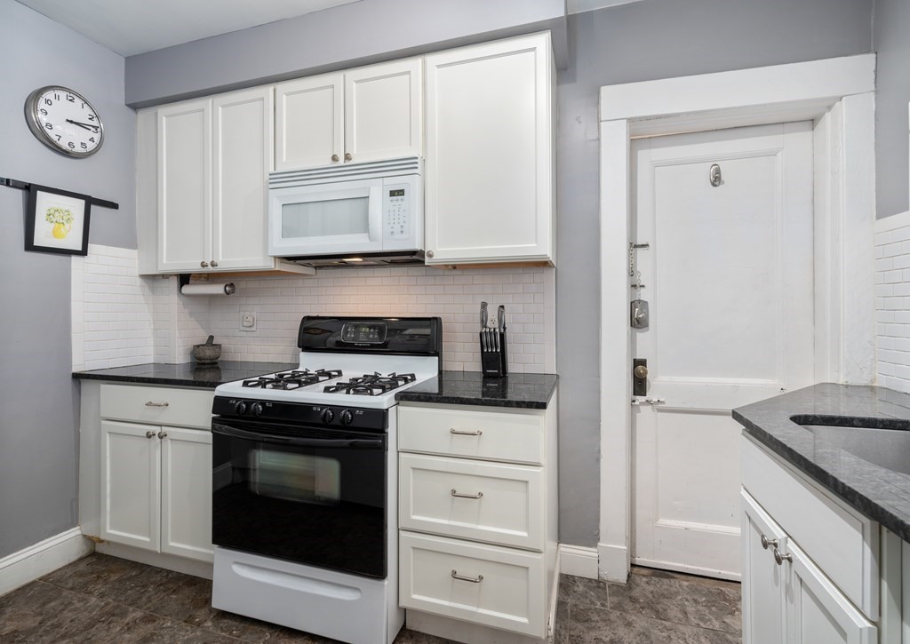 43 Linnaean Street, Unit 32 Cambridge, MA 02138 - Photo 8 of 20 a kitchen with white cabinets and stainless steel appliances