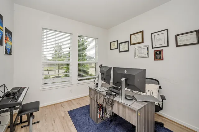 a view of a workspace with furniture and a window