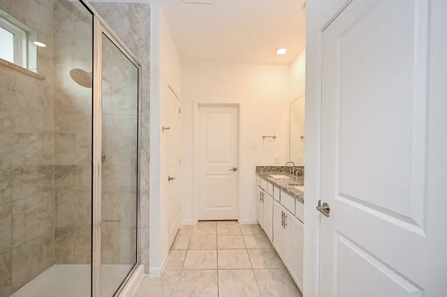 a bathroom with a granite countertop sink a mirror and a shower
