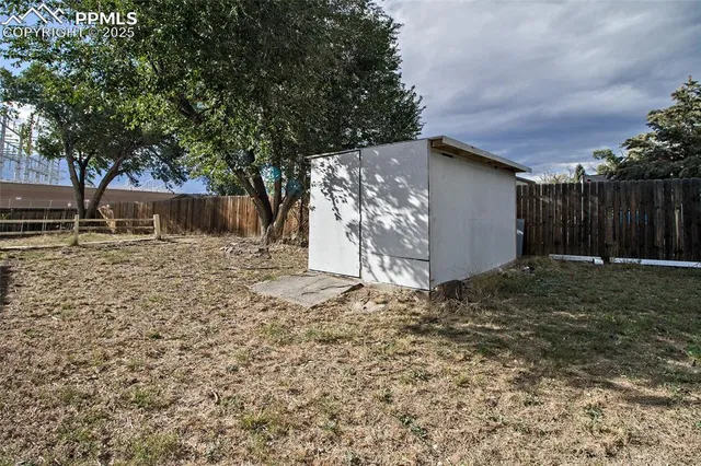 a view of a backyard with wooden fence