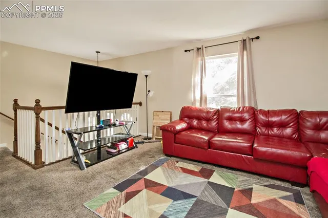 a living room with furniture a flat screen tv and a window