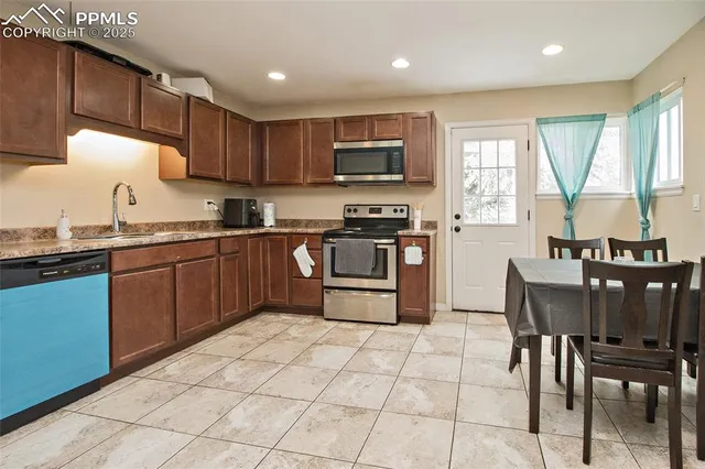a kitchen with stainless steel appliances granite countertop a stove top oven a sink dishwasher and white cabinets