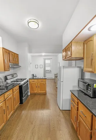 a kitchen with stainless steel appliances granite countertop a refrigerator and a stove top oven