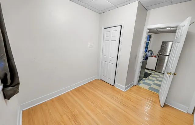 a view of empty room with wooden floor