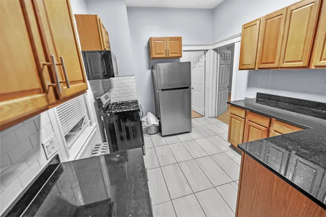 a kitchen with stainless steel appliances granite countertop a refrigerator and a stove top oven