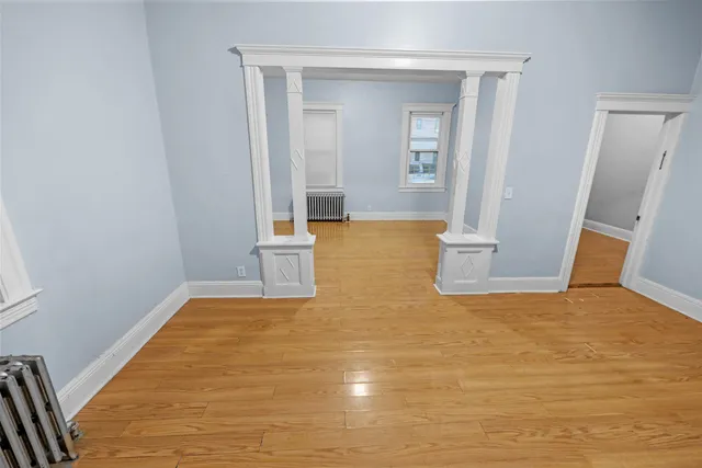 a view of empty room with wooden floor