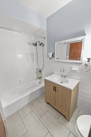 a bathroom with a tub sink and mirror