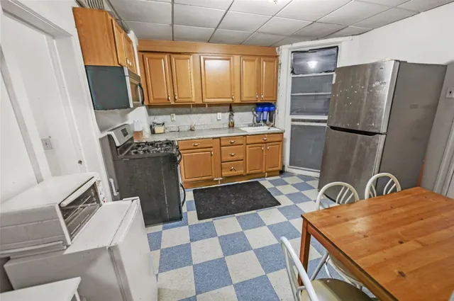 a kitchen with stainless steel appliances a sink a stove a refrigerator and cabinets