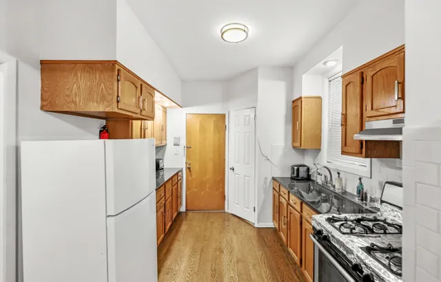 a kitchen with stainless steel appliances granite countertop a refrigerator a stove and a sink