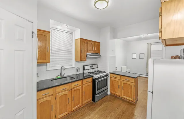a kitchen with stainless steel appliances granite countertop a sink stove and refrigerator