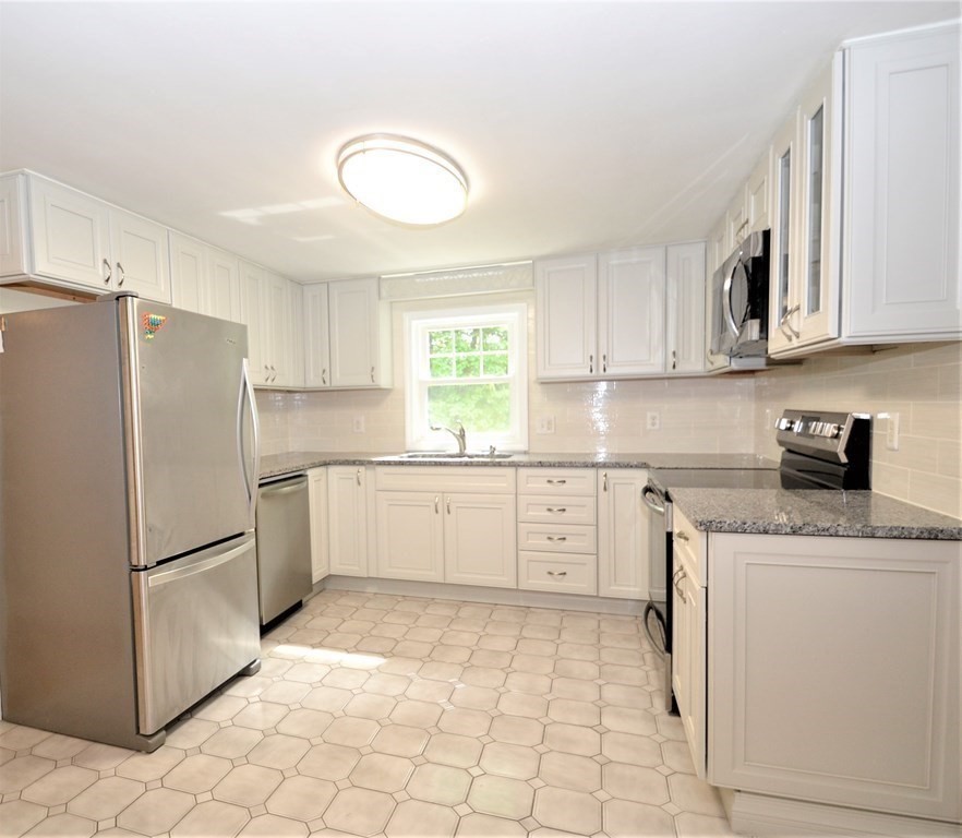95 Pine Hill Road Ashland, MA 01721 - Photo 2 of 30 a kitchen with a refrigerator sink and cabinets