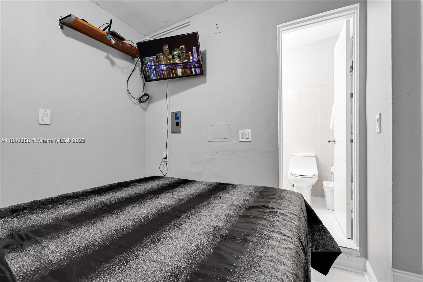 1761 Southwest 14th Street Miami, FL 33145 - Photo 27 of 37 a bedroom with a bed and a window