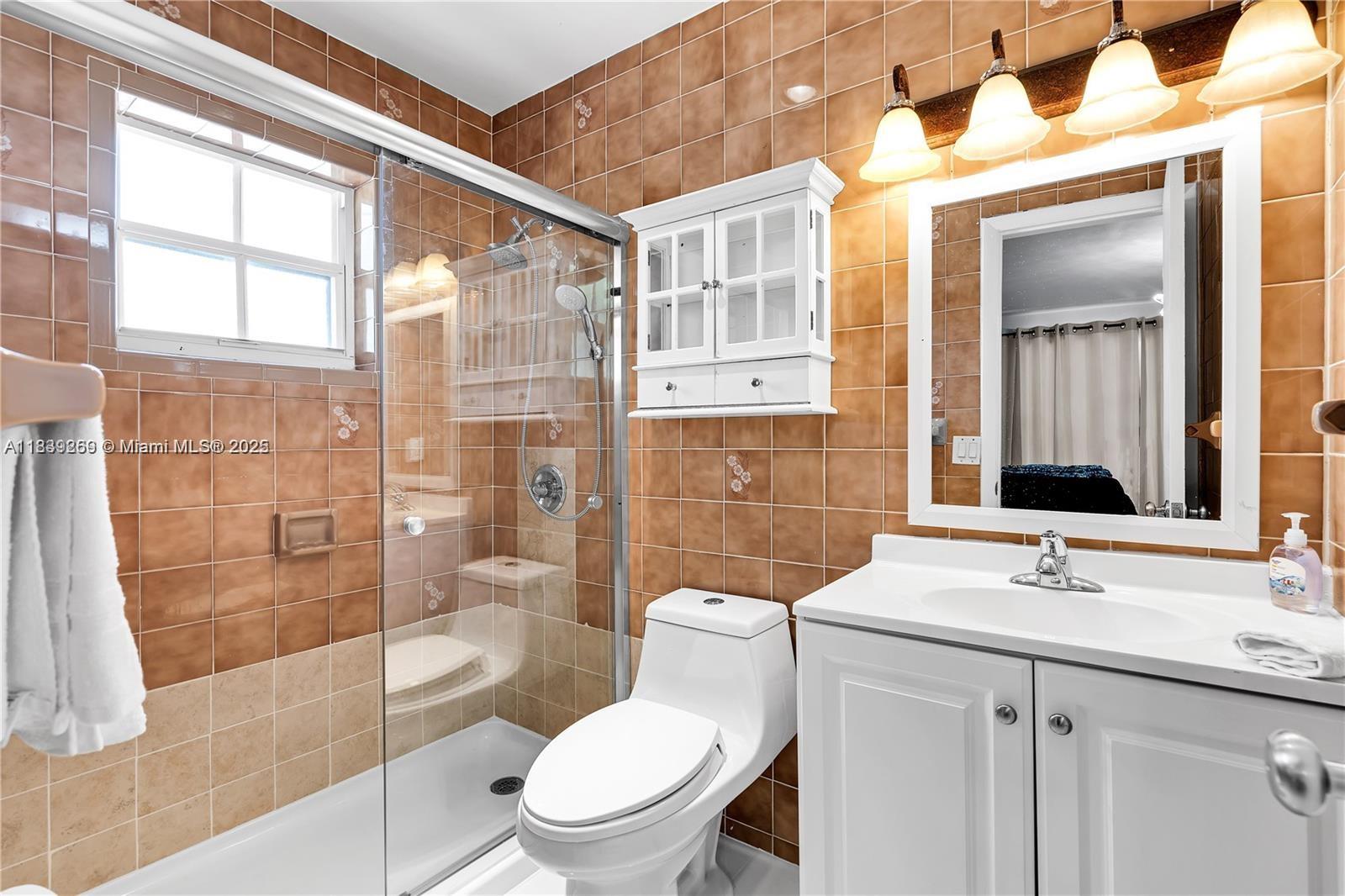 1761 Southwest 14th Street Miami, FL 33145 - Photo 37 of 37 a bathroom with a toilet a sink a glass door a shower and a mirror