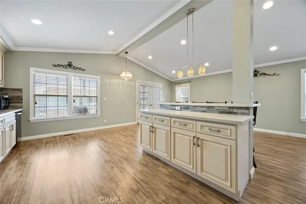 a large kitchen with granite countertop a large counter top space a sink stainless steel appliances and cabinets