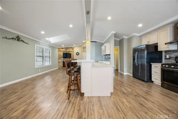 a kitchen with stainless steel appliances a refrigerator a stove top oven and wooden floors