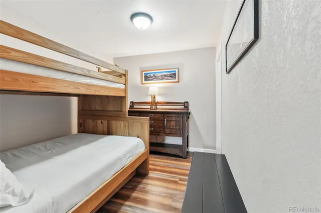 a bedroom with a bed and wooden floor