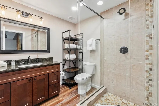 a bathroom with a double vanity sink toilet mirror and shower