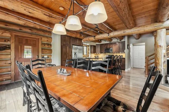 a dining room with wooden floor a table and chairs