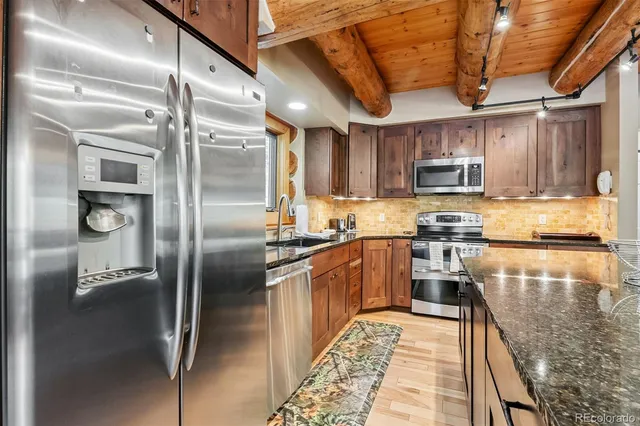 a kitchen with kitchen island a counter top space a refrigerator and a sink