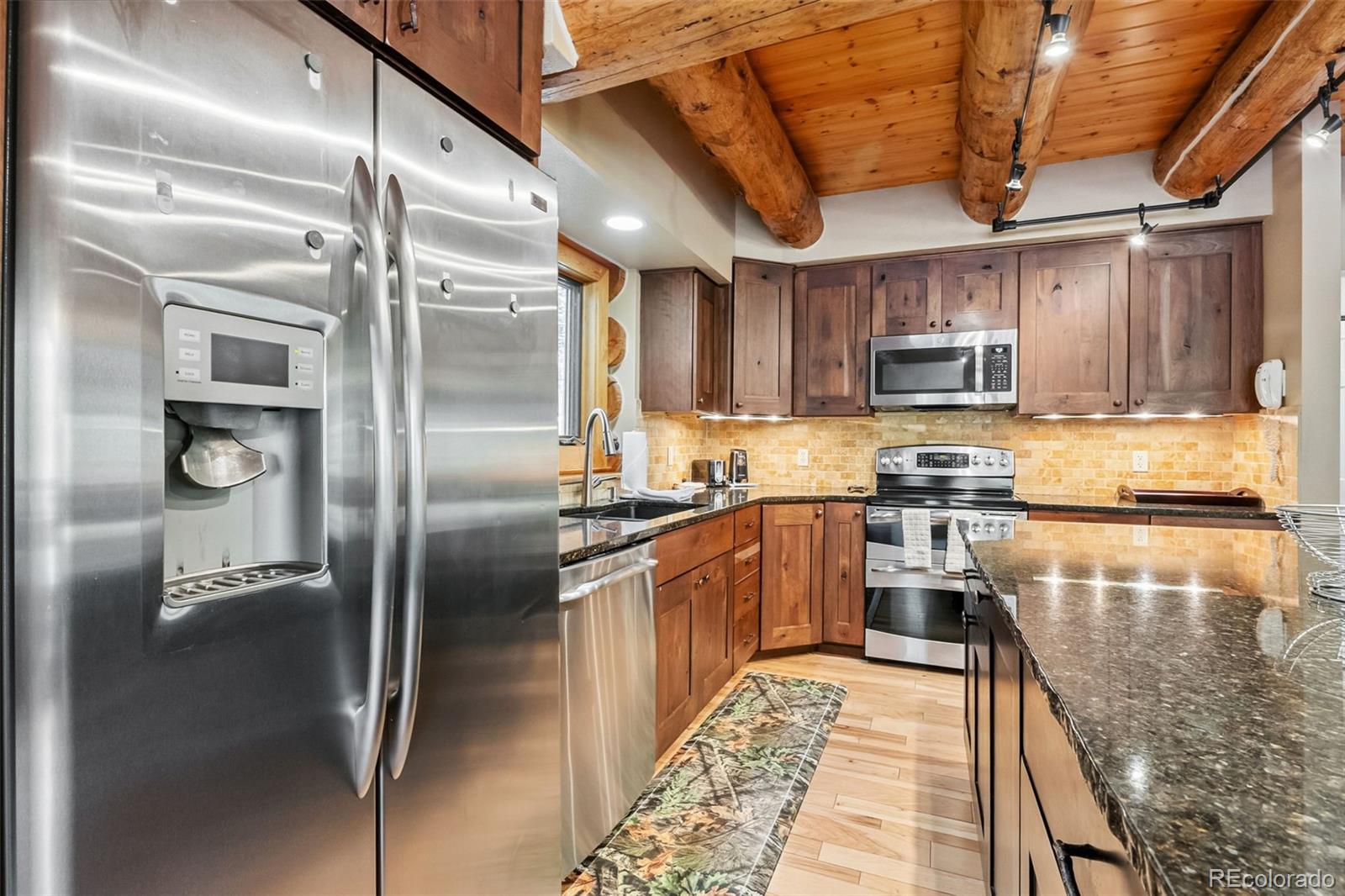 46 Indiana Creek Road Breckenridge, CO 80424 - Photo 8 of 50 a kitchen with kitchen island a counter top space a refrigerator and a sink