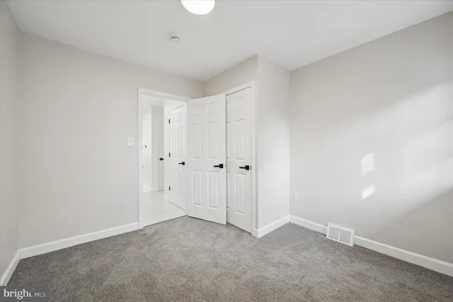 an empty room with a ceiling fan and window