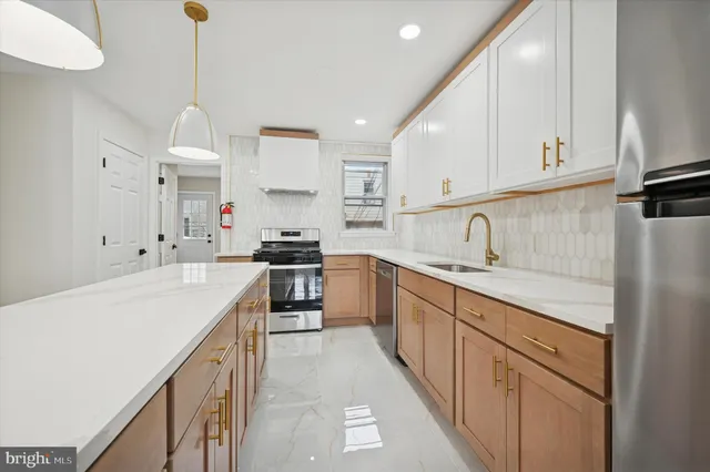 a kitchen with kitchen island a counter top space a refrigerator and cabinets