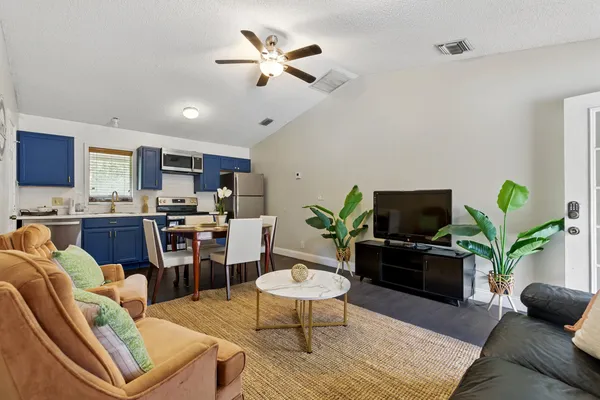 a living room with furniture a dining table and a potted plant