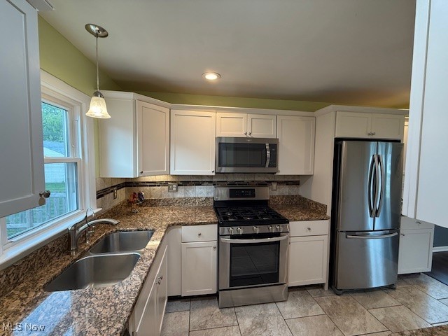 30101 Oakdale Road Willowick, OH 44095 - Photo 6 of 17 Kitchen featuring stainless steel appliances, a sink, white cabinets, pendant lighting, and dark stone counters