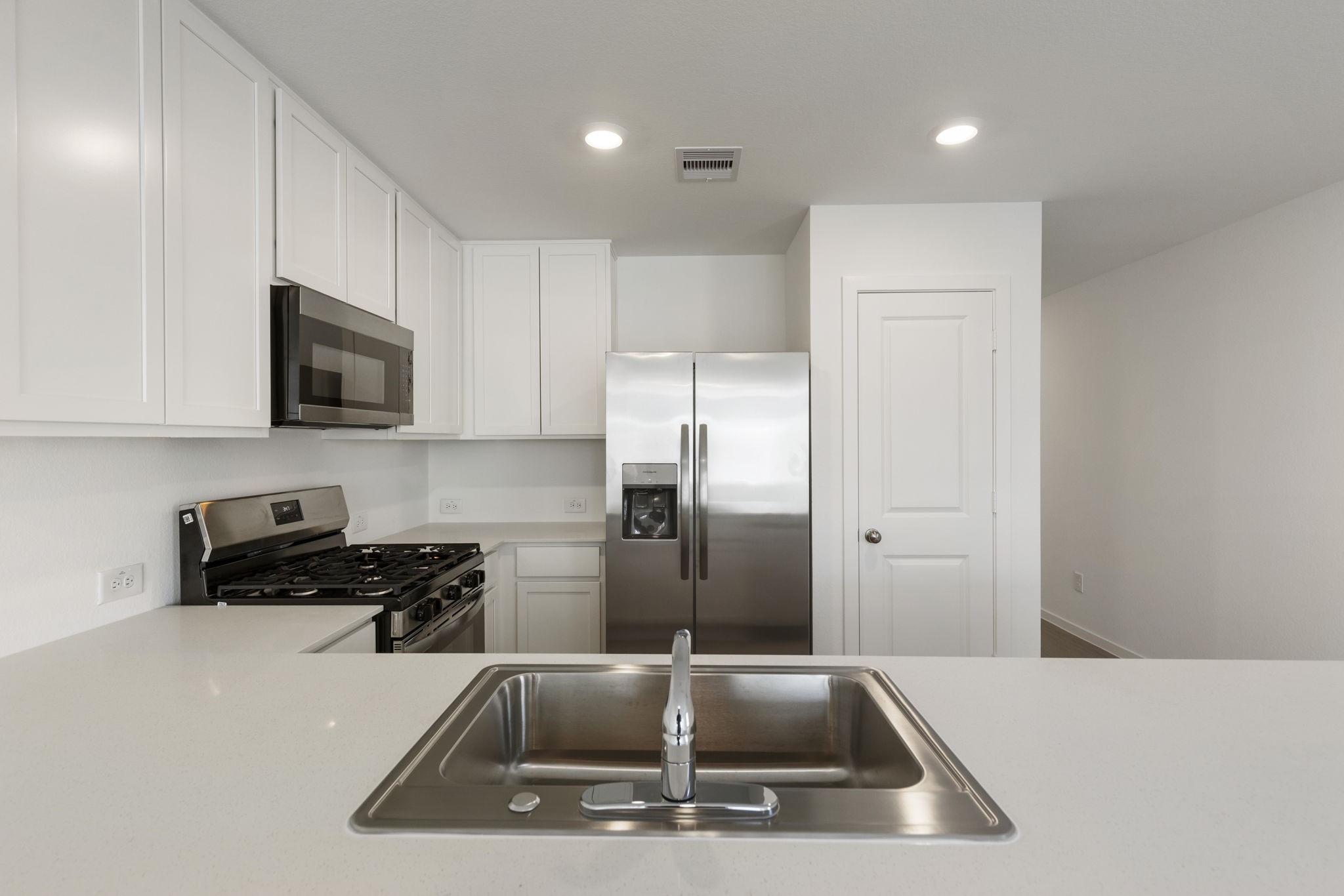 490 Southern Magnolia Way Magnolia, TX 77354 - Photo 10 of 25 a kitchen with a sink a refrigerator and microwave
