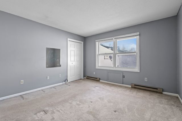 an empty room with windows and closet