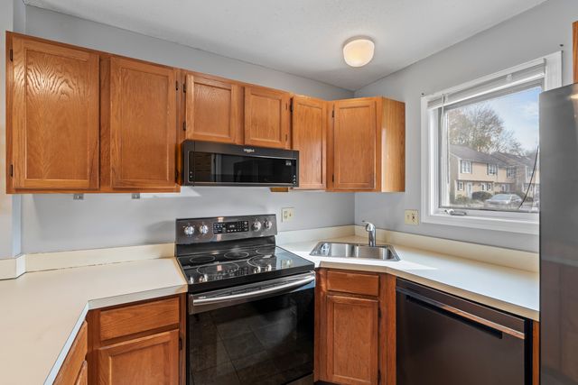 a kitchen with stainless steel appliances wooden cabinets and a stove top oven