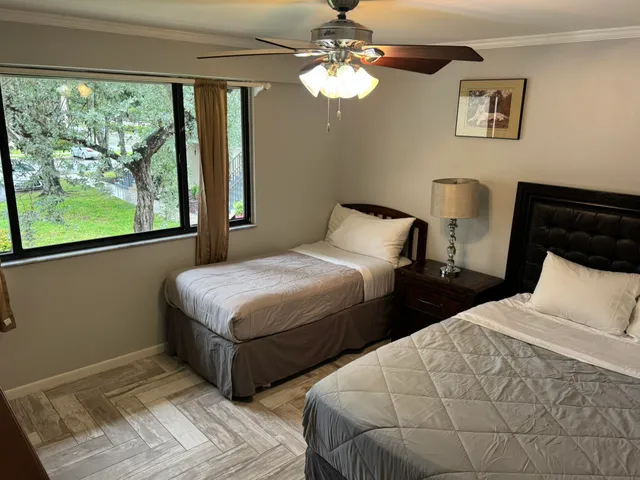 a bedroom with two beds and a window
