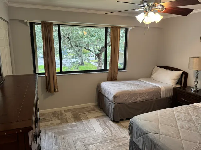 a bedroom with two beds and a large window