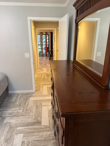 a view of a hallway with a window and wooden floor