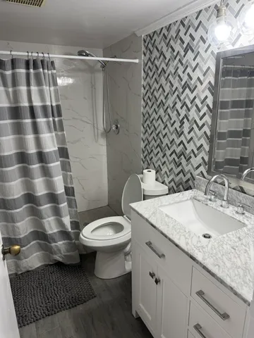 a bathroom with a sink toilet and shower