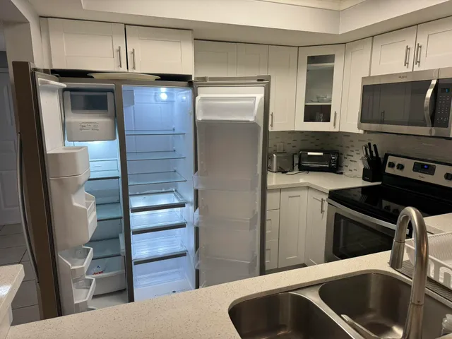 a kitchen with stainless steel appliances granite countertop a refrigerator and a sink